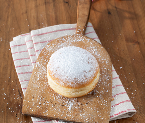 Ein Krapfen auf einem Holzbrett angerichtet